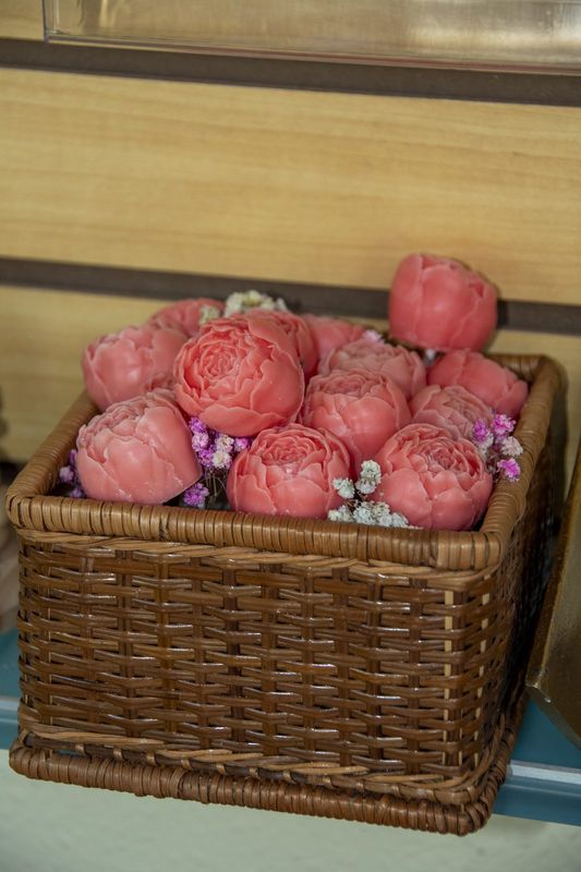A wicker basket filled with pink peony candles